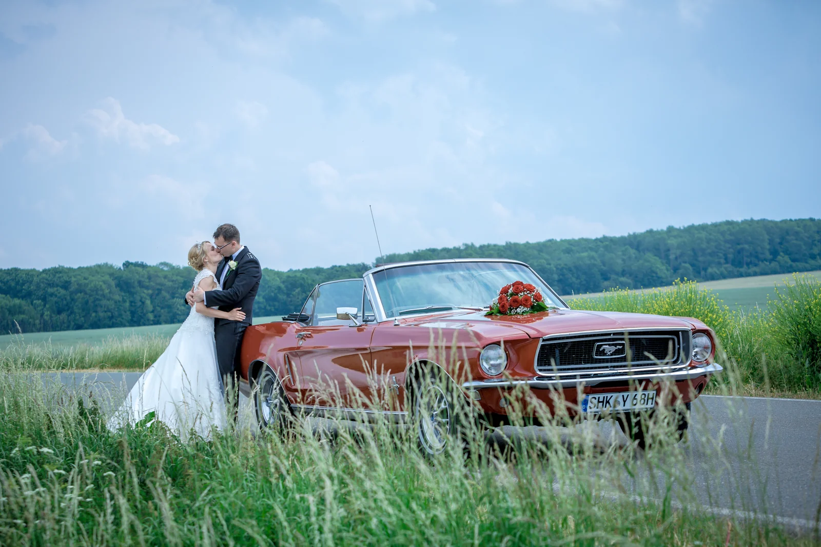 Ein Kuss am roten Hochzeitsauto – Hochzeitsreportage von Rosi und Chris