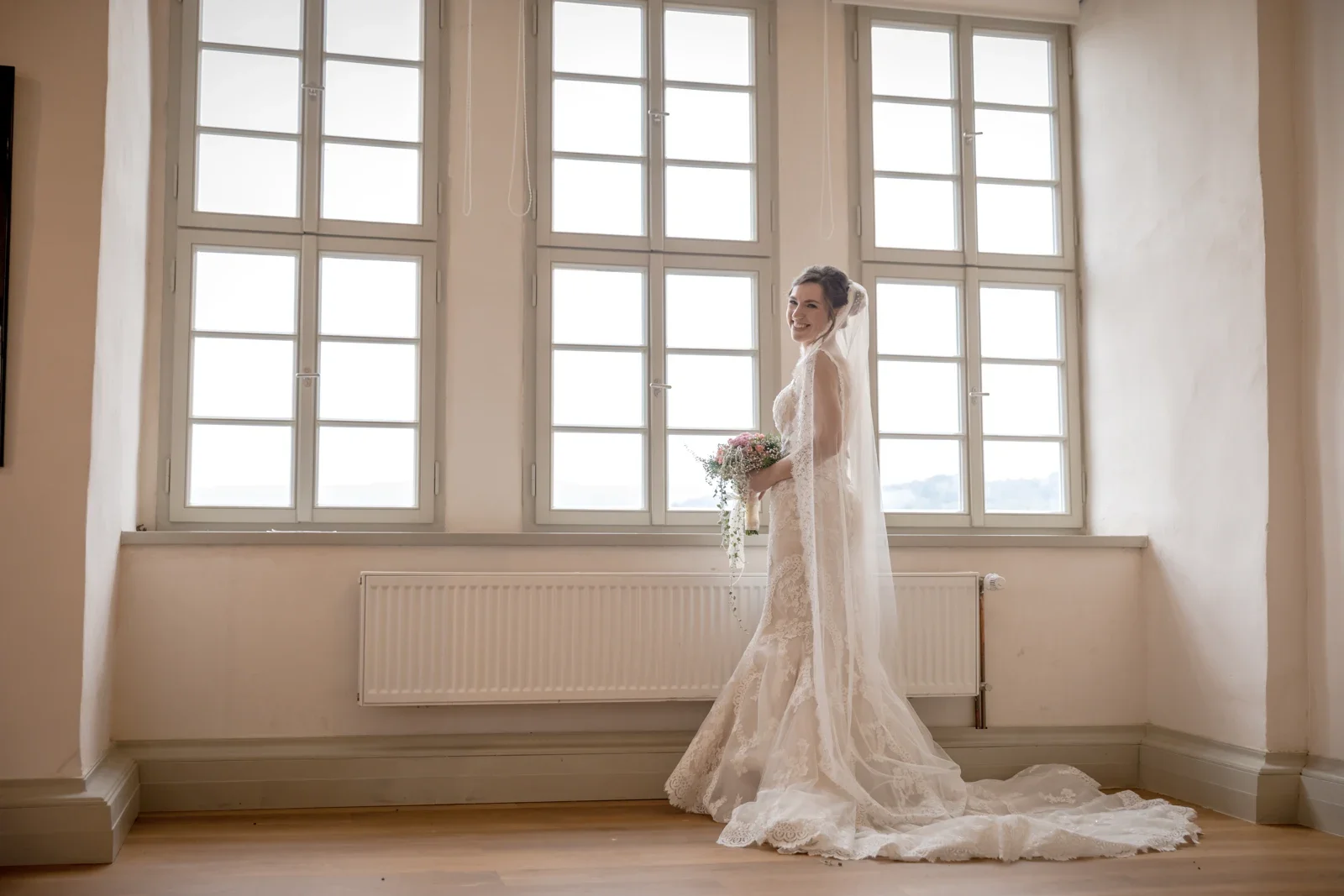 Steffi mit ihrem Brautstrauß am Schlossfenster – Hochzeit von Daniel und Steffi auf Schloss Heringen