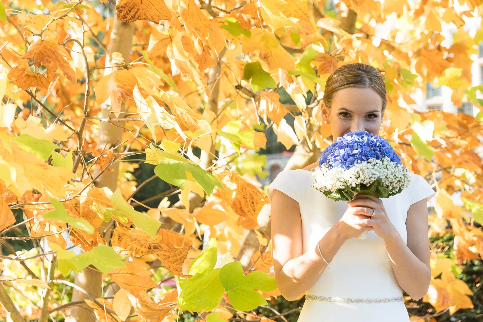 Christiane mit blauem Brautstrauß im Herbstlaub – Hochzeit von Christiane und Felix in Schloss Kronberg