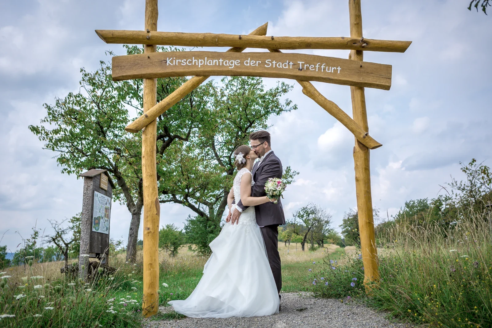 Ein Kuss unter dem hölzernen Torbogen – Hochzeit von Marielle und Micha