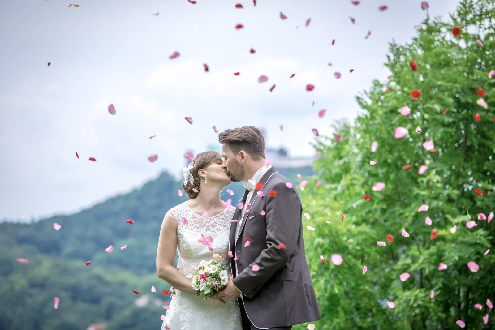 Blütenblätter fliegen über das Brautpaar – Hochzeit von Marielle und Micha