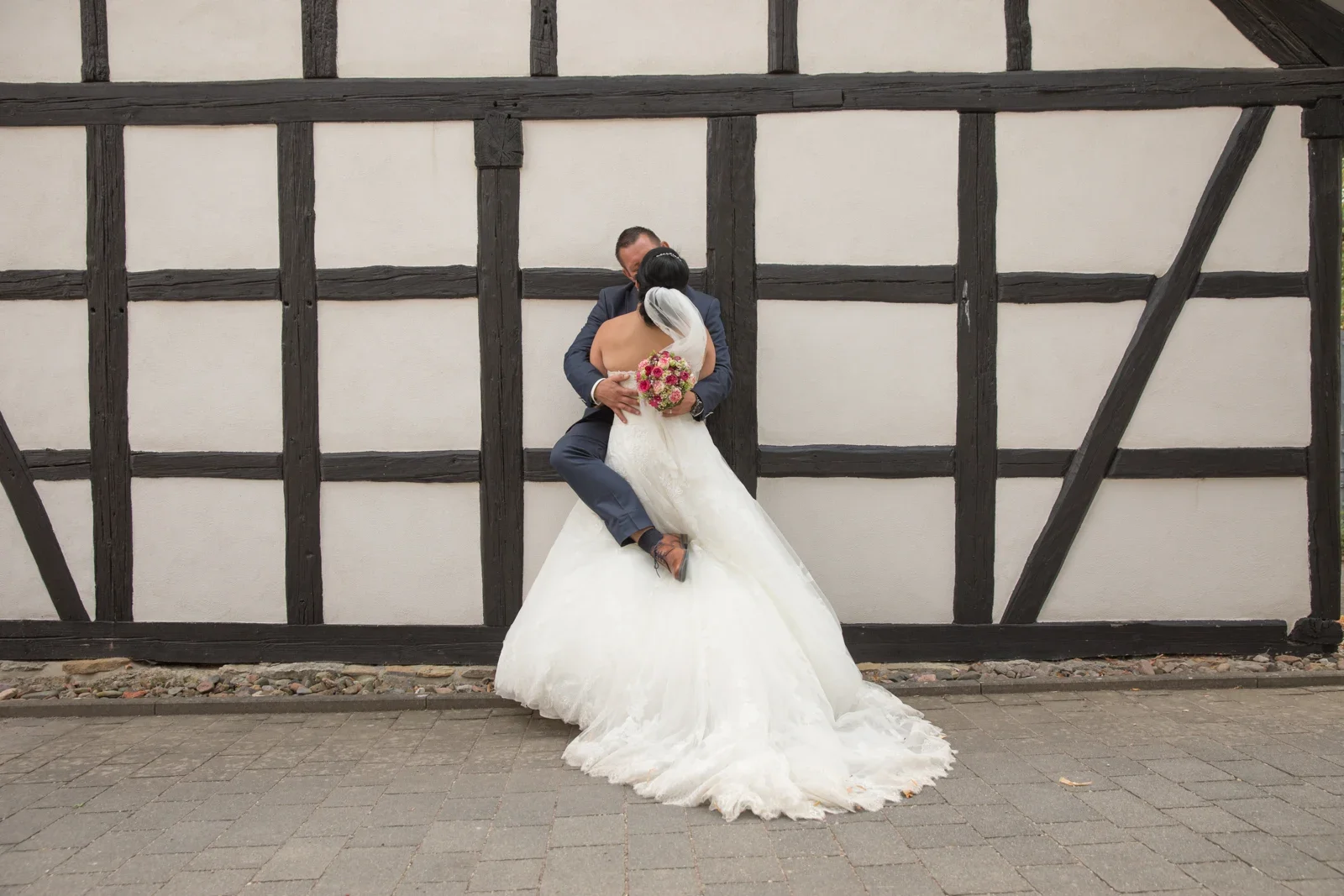 Ein Paarbild vor der Fachwerkfassade – Hochzeit von Dana und Matthias in Volkenroda und Mühlhausen