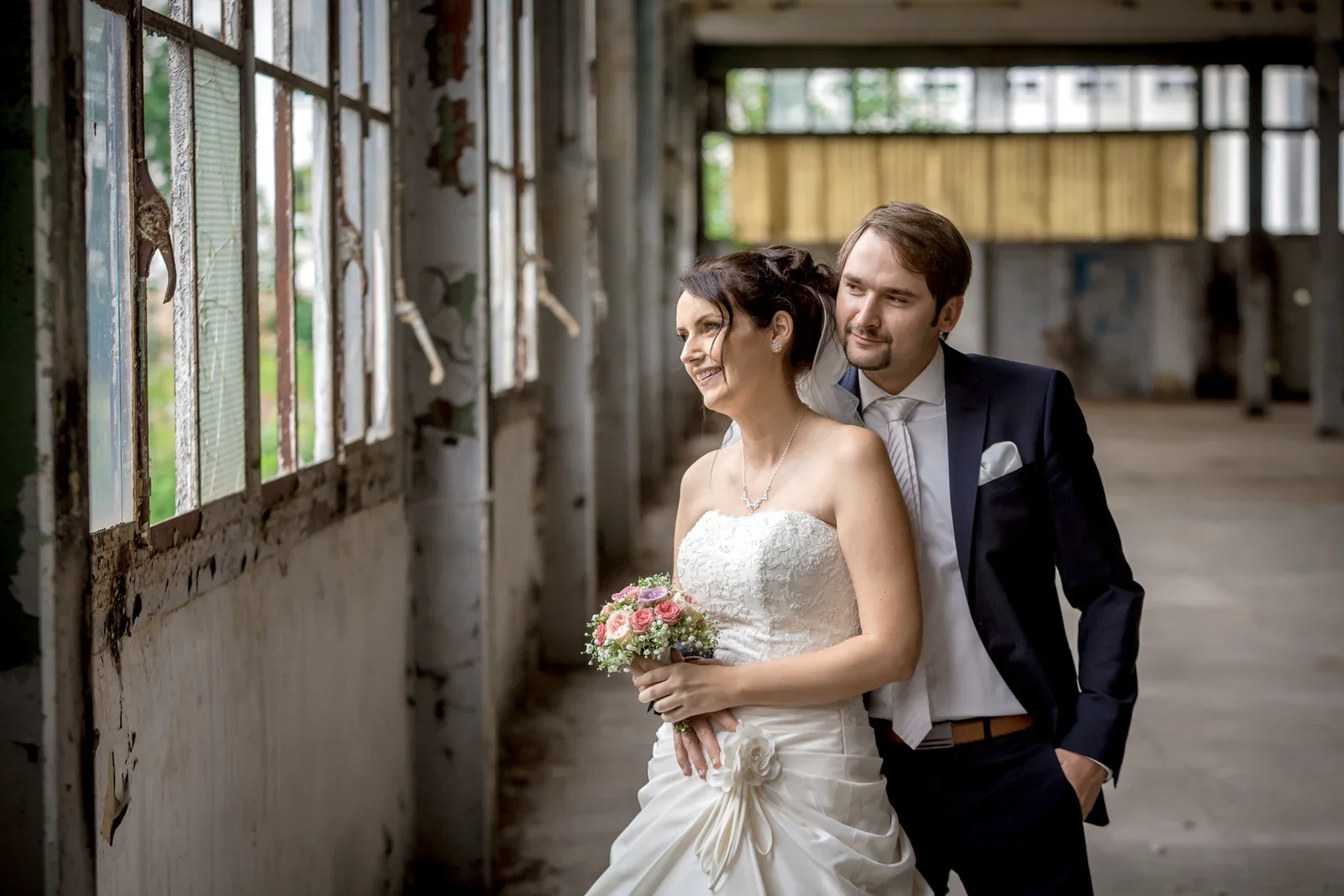Ein Paarportrait am Fenster der alten Autofabrik – Hochzeit von Sabine und Robert auf der Wartburg und in Gotha
