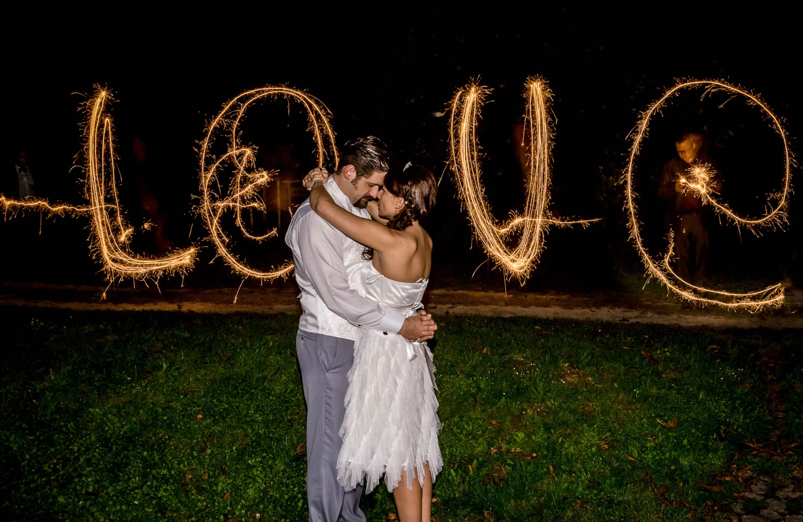 Brautpaar vor dem mit Licht geschriebenen Wort Love