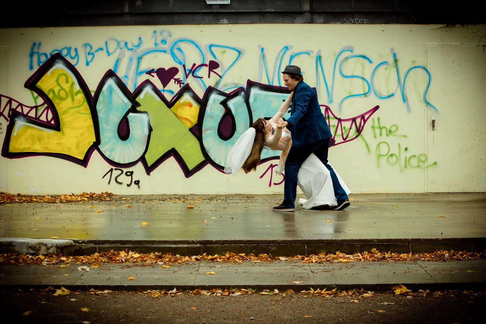 Brautpaar vor einer bunten Graffitiwand