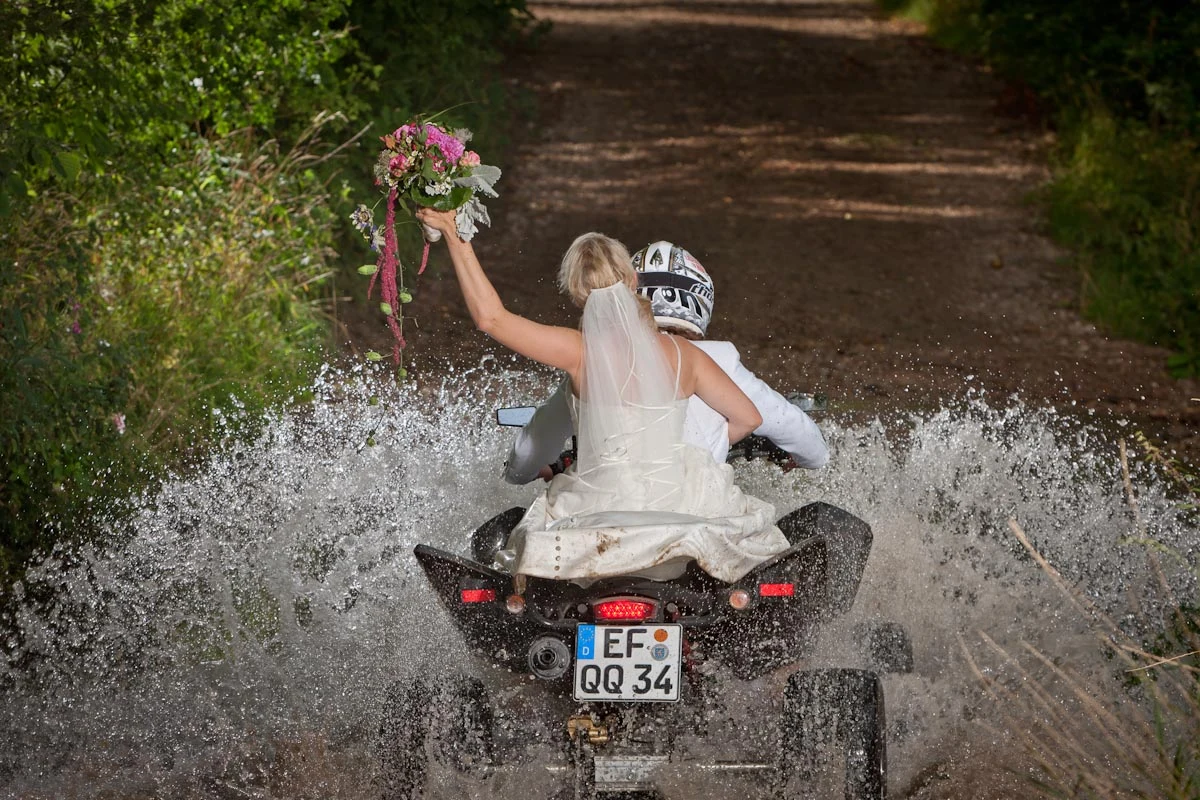 Brautpaar auf einem Quad bei einem Trash-the-Dress-Shooting
