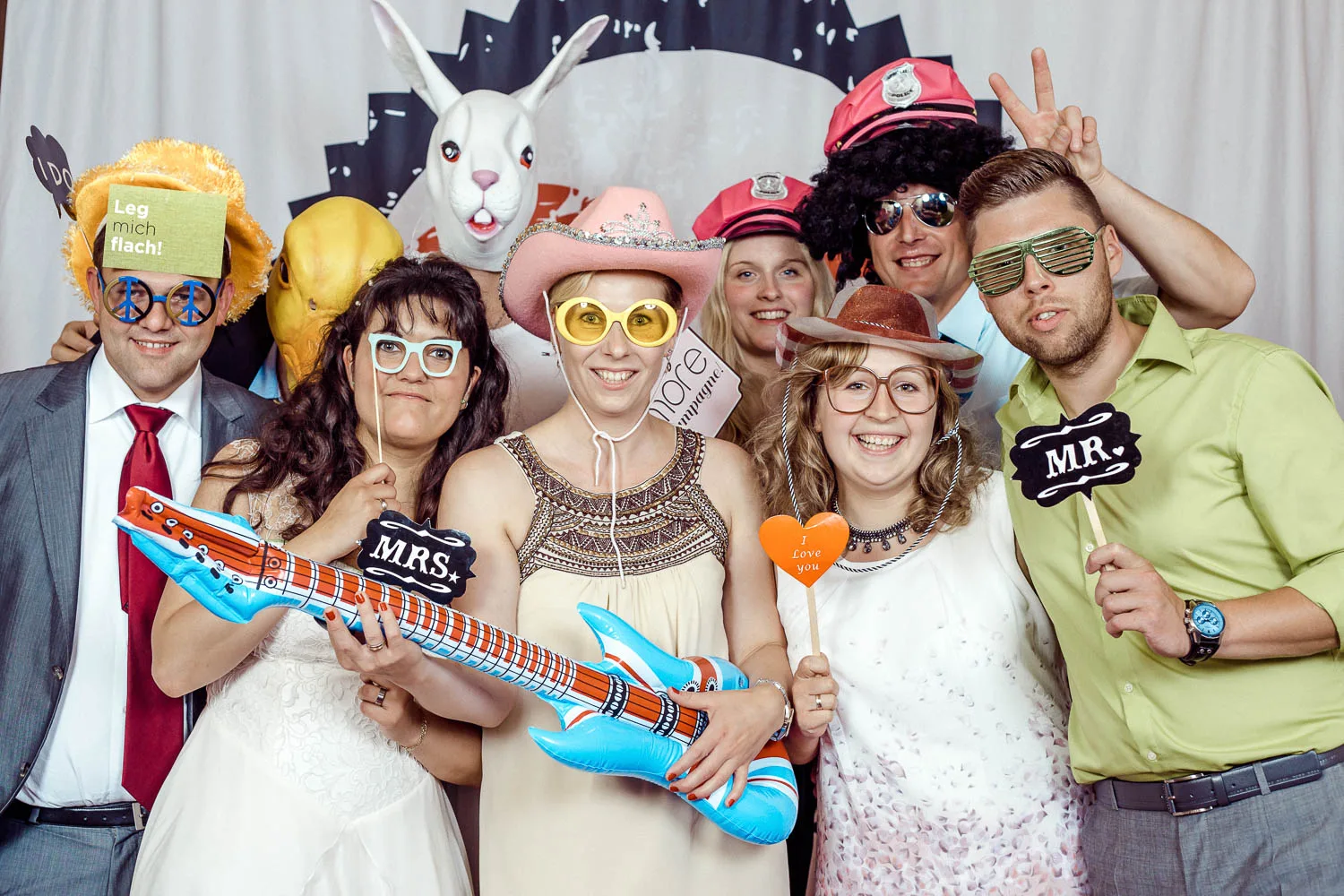 Bunte Hochzeitsgruppe vor dem Just-Married-Hintergrund – Beispiel aus der Fotobox-Galerie von Delf Zeh