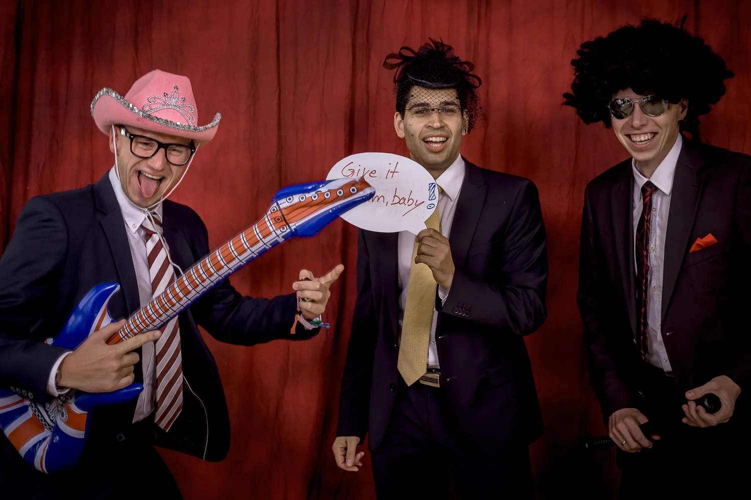 Drei Gäste mit Perücken und aufblasbarer Gitarre – Beispiel aus der Fotobox-Galerie von Delf Zeh