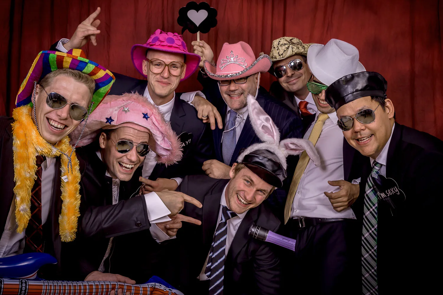 Große Hochzeitsgruppe mit Hüten, Brillen und Requisiten | DELF ZEH pictures Hochzeitsgäste mit bunten Hüten und Requisiten vor der Fotobox