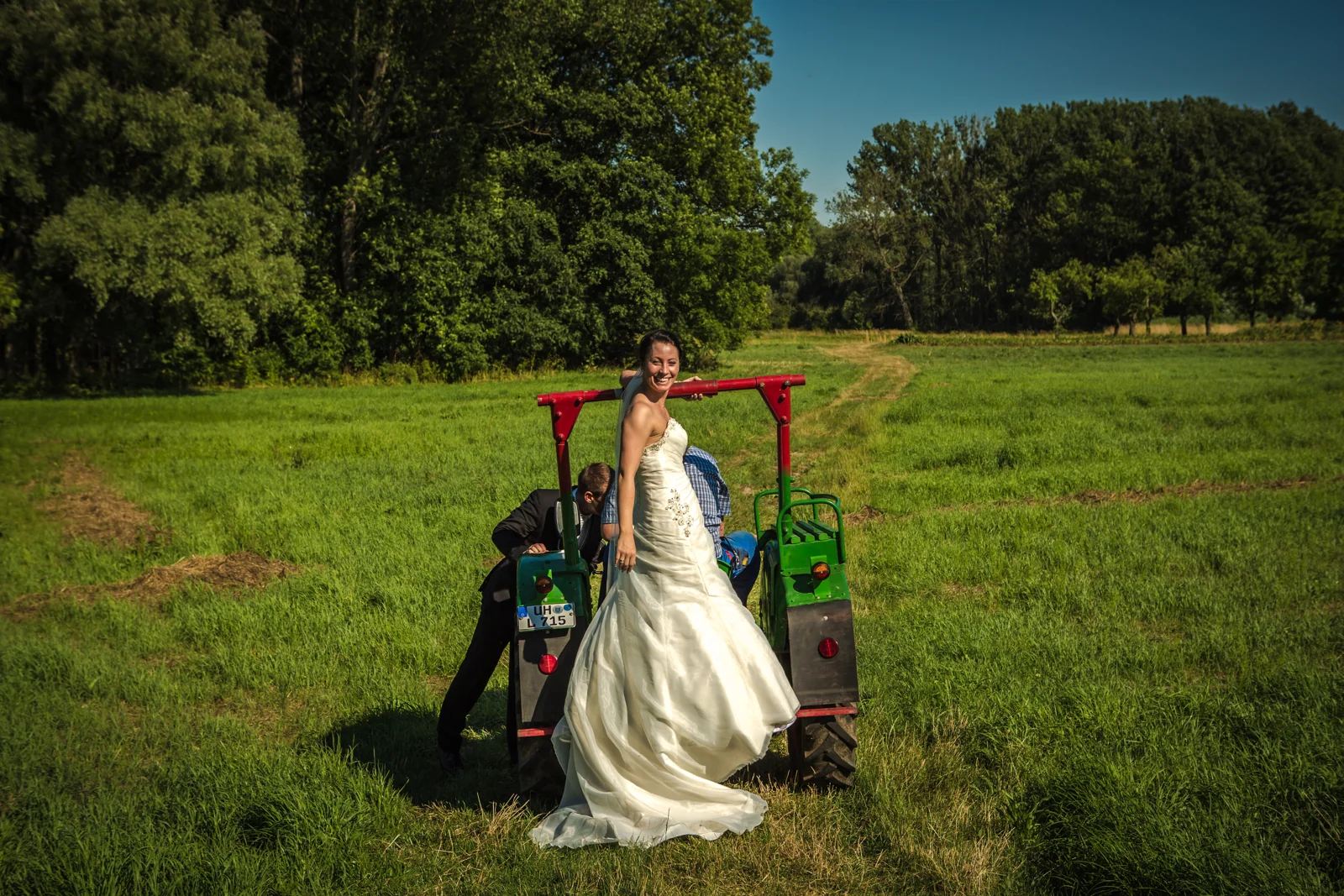 Sabrina vor dem Traktor auf der Wiese – Trash the Dress mit Sabrina und Jan