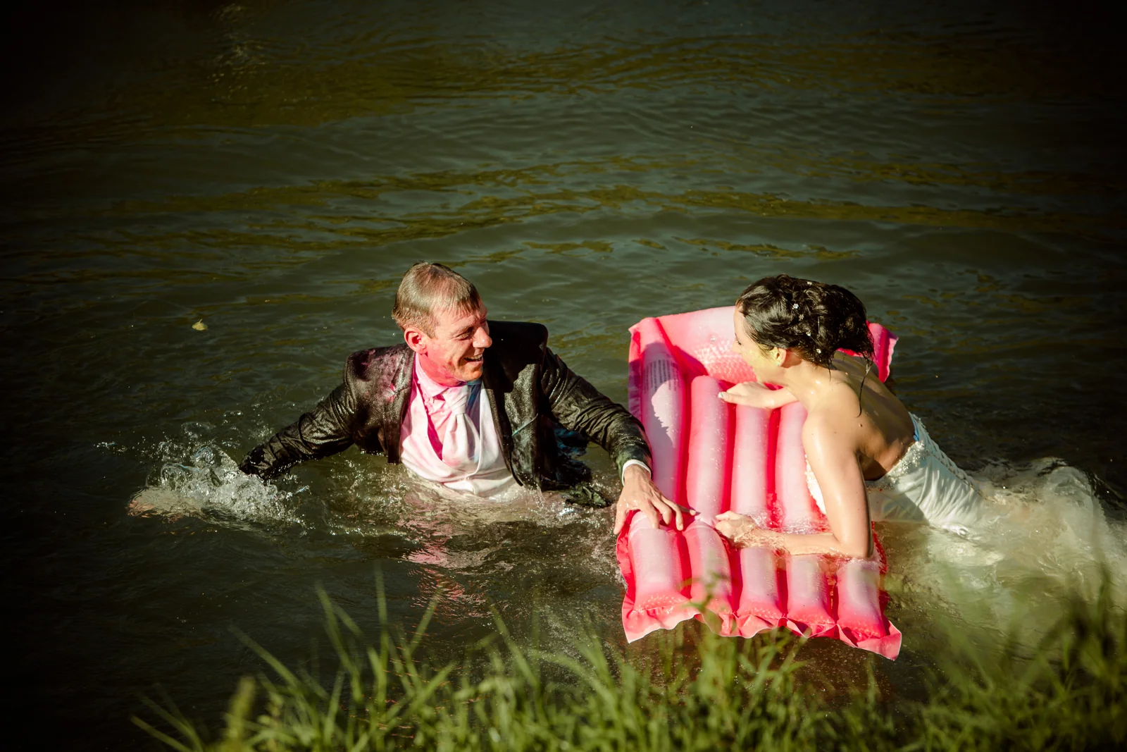Das Brautpaar im Wasser mit einer pinken Luftmatratze – Trash the Dress mit Sabrina und Jan