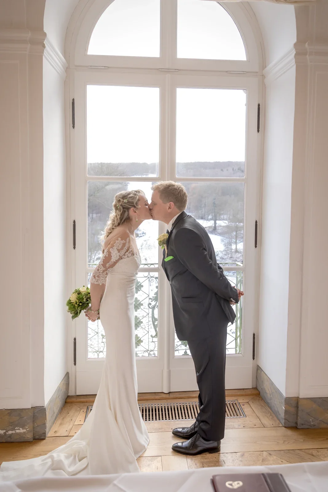 Ein Kuss am großen Schlossfenster – Winterhochzeit von Anika und Marcus auf Schloss Ettersburg und in Weimar
